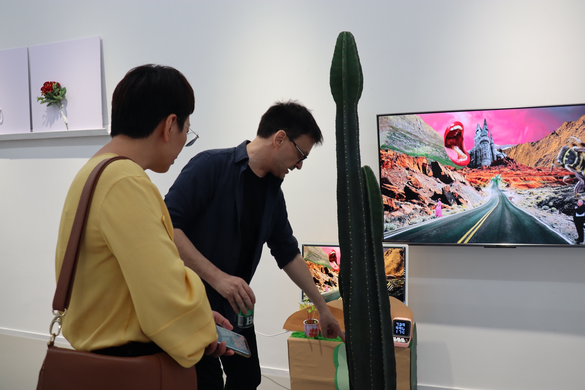 A visitor testing the plant interaction while another person watches the animated screen
