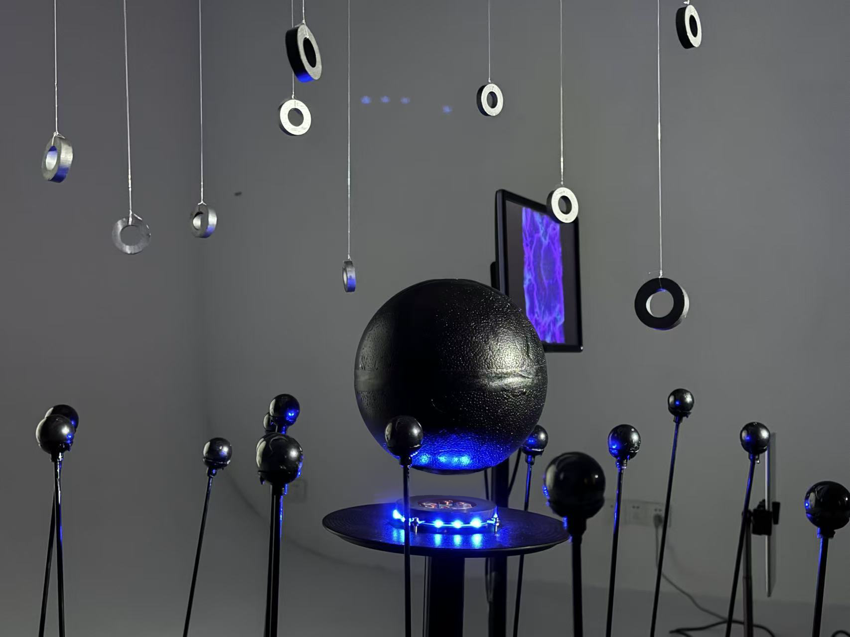 Close view of the levitating central sphere, magnetic elements and suspended rings